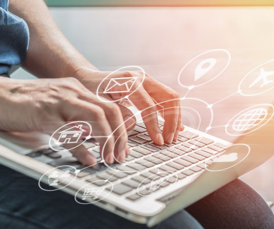 Hands typing on a laptop with digital icons.