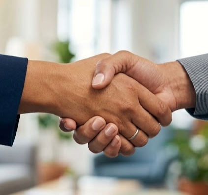 Close-up of two people shaking hands in a professional setting.